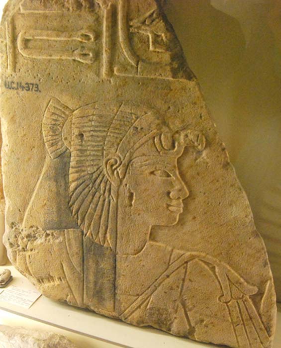 Detail from a sandstone block fragment from the mortuary temple of Amenhotep III depicts Princess Sitamun wearing a vulture headdress and holding a floral scepter. Petrie Museum, London. 