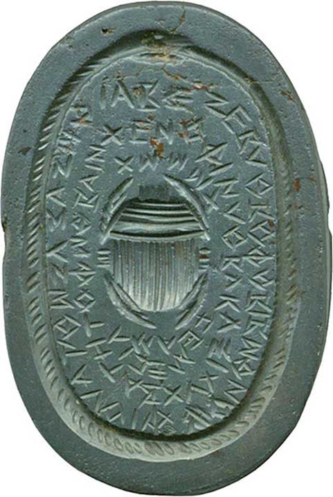 This gem displays an "uroborus," (a serpent which swallows its own tail to create a closed circle) encircling a scarab beetle and a long inscription, which is made up of magical words. Above the god is a head of Hathor with a winged sun-disk. Gems with magical icons and words were believed to be protective. Egypt.