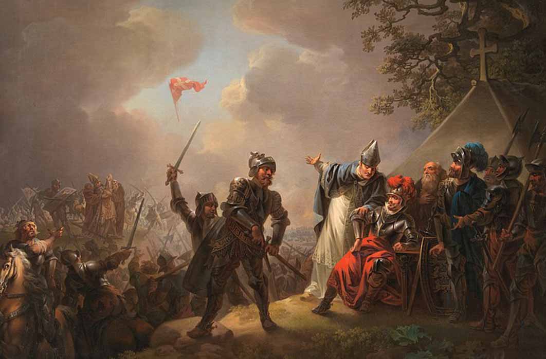 Dannebrog falling from the sky during the Battle of Lindanise with Roskilde-bishop Peder Jacobsen pointing at Dannebrog while informing king Valdemar II of Denmark, by Christian August Lorentzen (1219) Statens Museum for Kunst (CC0)