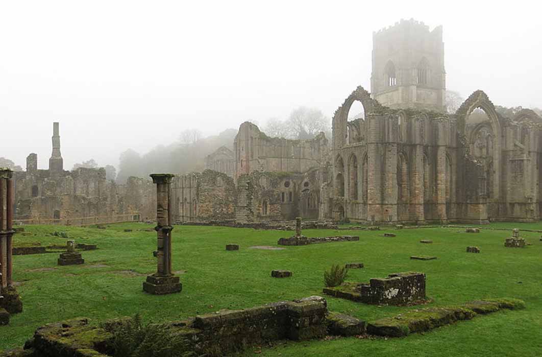 Fountain Abbey grounds enveloped in morning mist, from the Infirmary (DrMoschi /CC BY-SA 4.0)
