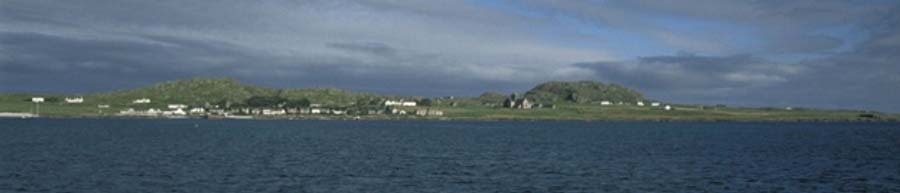 Iona as viewed from the island of Mull. The Abbey lies below the Dun (hillock) on the right and the main settlement of Baile Mòr is to the left. (Public Domain)