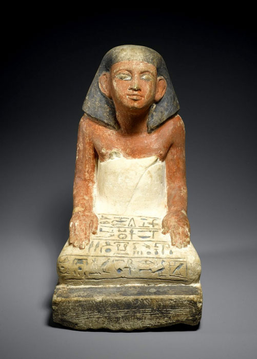 Limestone statue of Si-Hathor, a scribe. This statuette combines the seated image of the deceased with the base where the inscription would normally be carved. Here, the artist carved the offering prayer directly onto Si-Hathor’s garment, a solution that saved on the amount of stone to be purchased. Late 12th Dynasty to early 13th Dynasty. Brooklyn Museum.