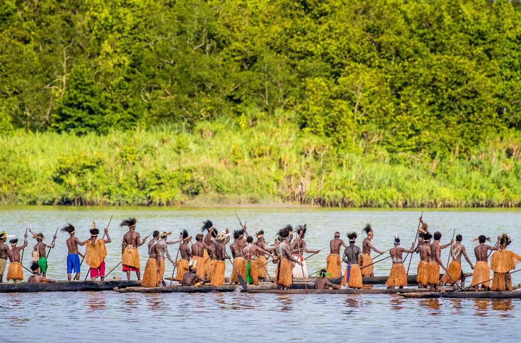 Men of the Asmat tribe are floating in a canoe on the river. Amanamkay. Village, Asmat province, Indonesia (gudkovandrey/ Adobe Stock)