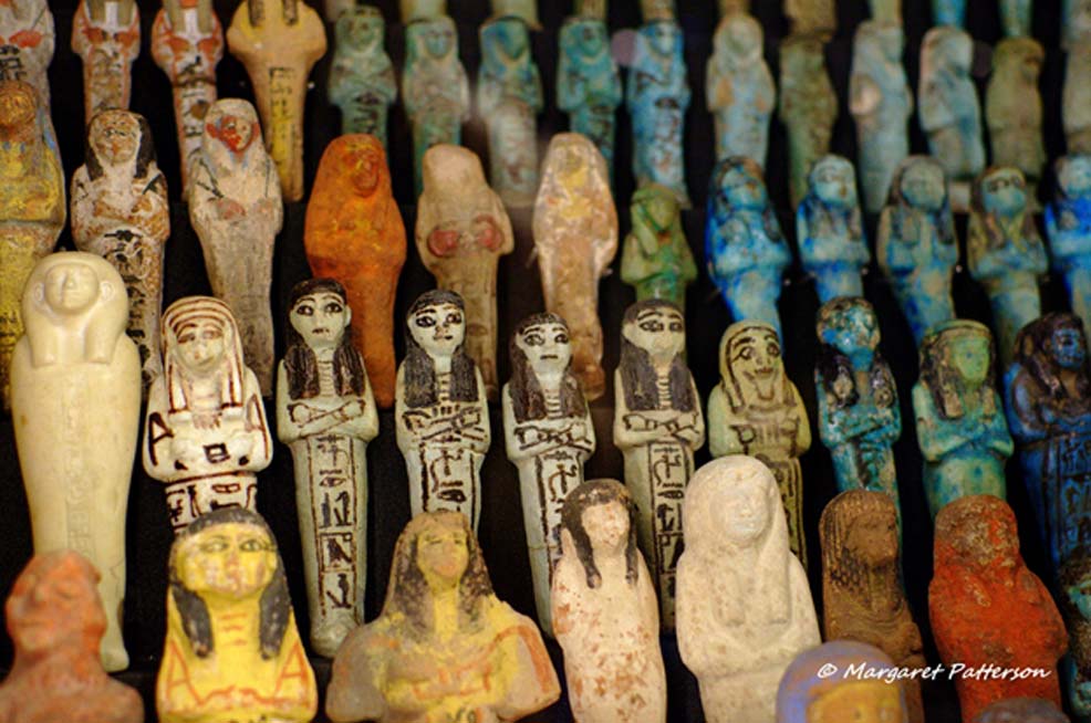 Shabti (or Ushabti) dolls were ancient Egyptian “Answerers” for the deceased in the Hereafter. An extensive collection of finely decorated figurines made from different materials, including faience and limestone, can be seen in this picture. Manchester Museum.
