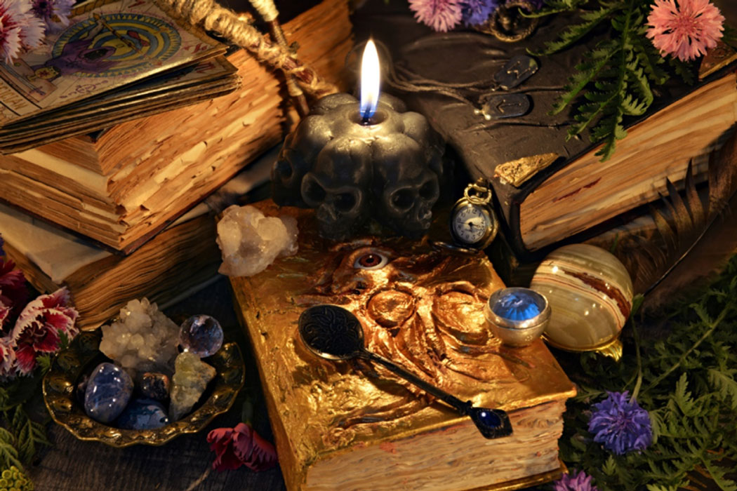 Ancient Sorcery: Antique witch book, black candle and ritual objects. 