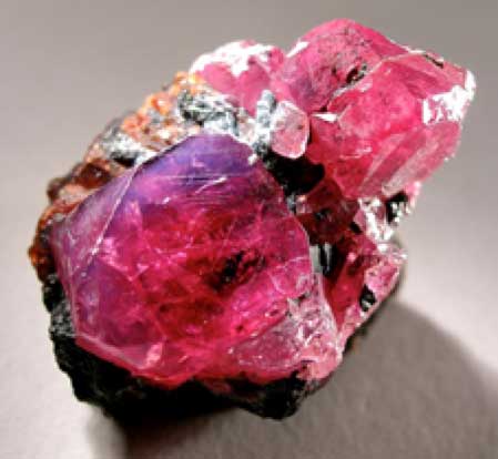 Two crystals of lustrous and translucent, cherry red ruby with exquisite micro-details on the faces and sharp bevelled edges. The larger one, exhibiting superb crystal form, measures 1.5 cm across. Recovered from: Winza, Mpapwa, Mpapwa (Mpwampwa) District, Dodoma region, Tanzania. (CC BY-SA 3.0)