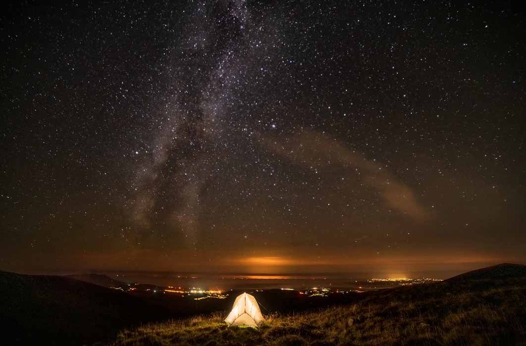 Milky way seen from a grassy summit in, Nantlle Valley in Gwynedd, Wales. ( Chin / Adobe Stock)