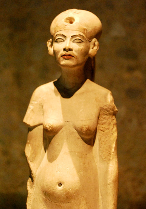 Far from being the iconic beauty depicted in her famous bust, Nefertiti is portrayed in a rather unflattering manner in this statuette from the latter-half of the Amarna era. Neues Museum, Berlin.