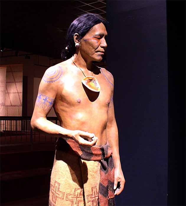 A diorama showing a Mississippian culture elite personage from the Cahokia site in Collinsville, Illinois. The figure wears a cloth skirt and sash, an engraved shell gorget, ear spools, and a falcon eye design painted on his face. (Herb Roe / CC BY-SA 3.0)