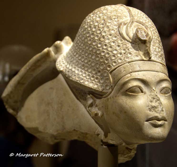 This head of indurated limestone is a fragment from a group statue that represented Amun seated on a throne, and Tutankhamun standing or kneeling in front of him. All that remains of the god is his right hand, which touches the back of the pharaoh’s crown in a gesture that signifies his investiture as king. Metropolitan Museum of Art, New York.
