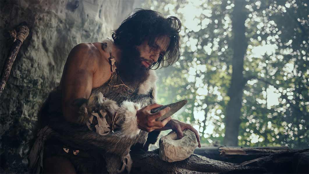 Caveman Makes First Primitive Tool for Hunting Animal Prey (Gorodenkoff / Adobe Stock)