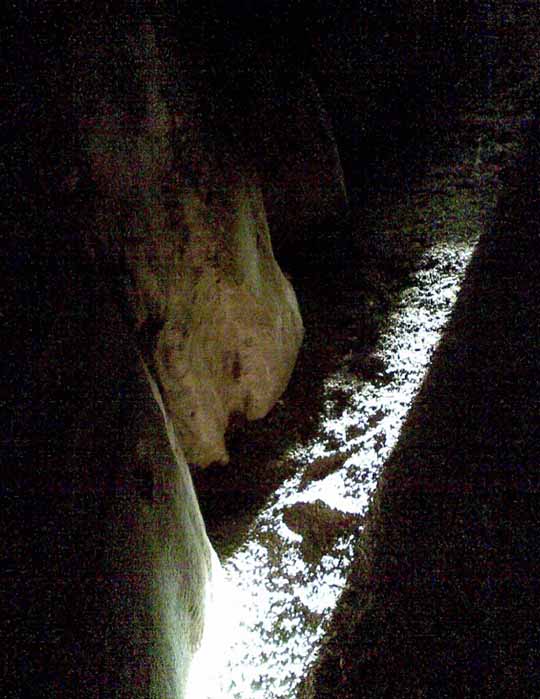A single shaft of Winter solstice, dying light, penetrates the passage at the Newgrange Neolithic tomb in Ireland.  (Public Domain).