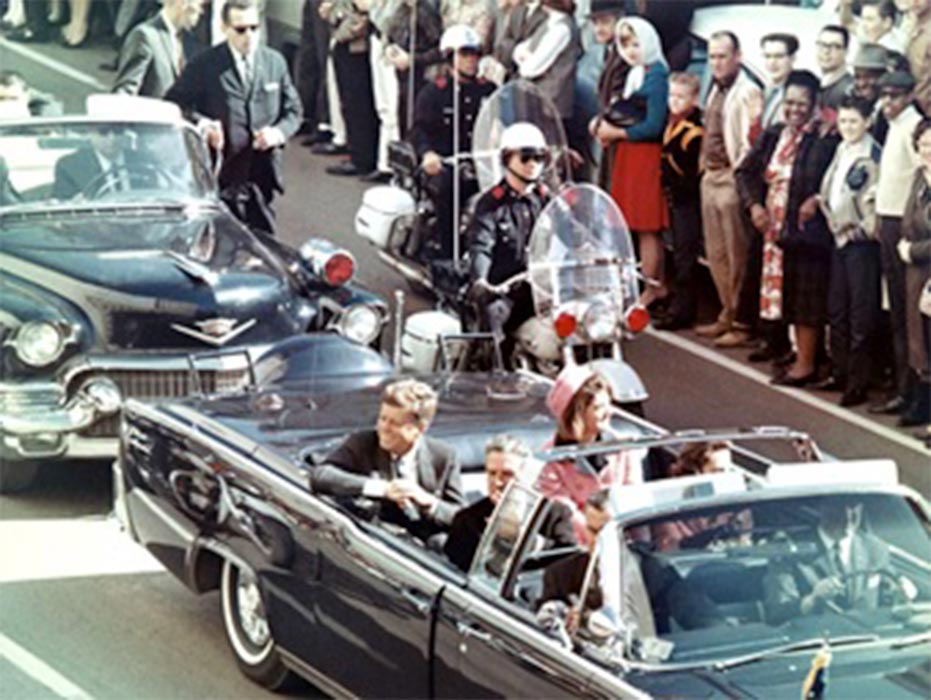 President Kennedy in the limousine in Dallas, Texas, on Main Street, minutes before the assassination. (Public Domain)