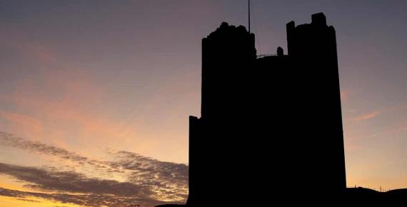 Sunset silhouette of Orford castle in Suffolk (Steve Mann / Adobe Stock)