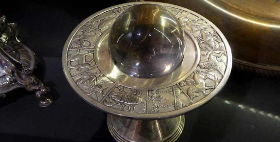 A crystal ball on a silver stand depicting the zodiac. Museum of Witchcraft and Magic in Boscastle, Cornwall. (Ethan Doyle White /CC BY-SA 4.0)