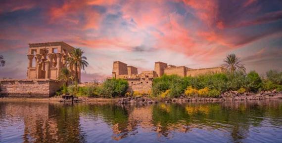 Incredible orange sunrise at the temple of Philae, a Graeco-Roman construction seen from the Nile river, a temple dedicated to Isis, goddess of love. (unai/Adobe Stock)