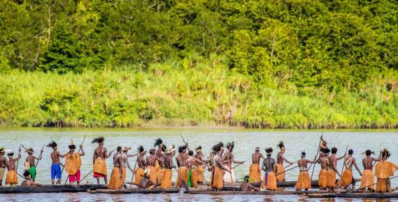 Men of the Asmat tribe are floating in a canoe on the river. Amanamkay. Village, Asmat province, Indonesia (gudkovandrey/ Adobe Stock)